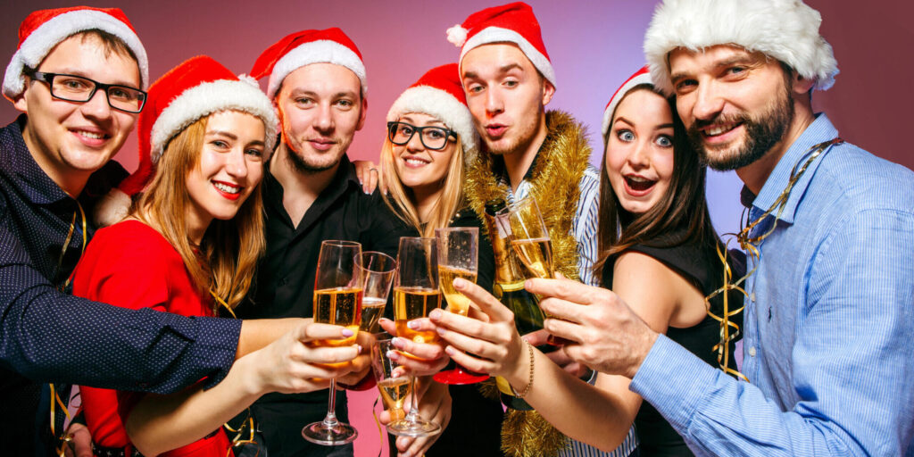 Many Young Women And Men Drinking At Christmas Party